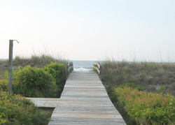 an outdoor shower along a boardwalk leading to the beach